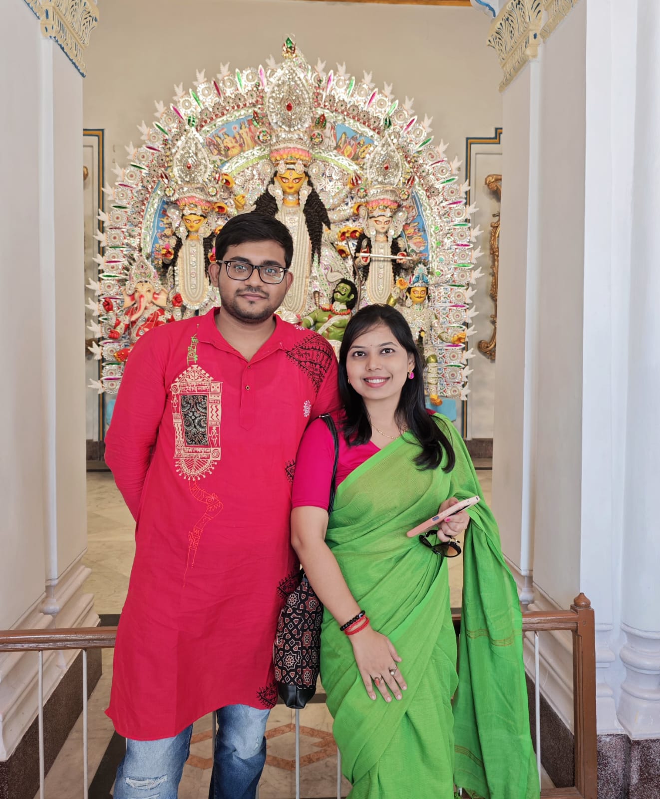 Soumya and Senjuti beneath a Durga idol